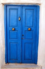 Fototapeta na wymiar Traditional wooden door in blue color, Isternia village, Tinos island, Cyclades, Greece.