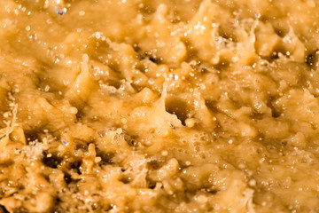 Rain drops fall into a dirty puddle