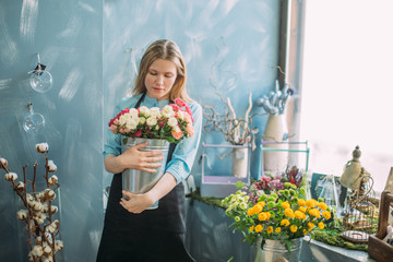 image of sentimental girl with flowers in flower shop. nice girl
