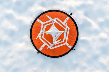 White drone camera with drone port and white snow and field in background