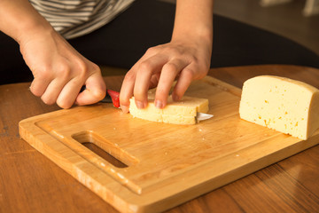 Slicing cheese with a knife on the board