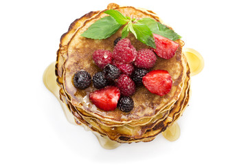 Delicious pancakes with berries and maple syrup top view, white background
