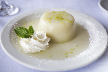 Dessert. Lemon Coconut Panna Cotta on a white plate close-up.