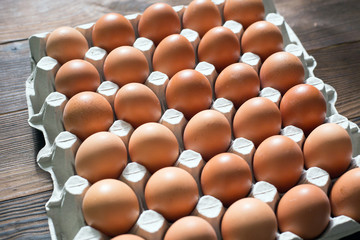 Fresh brown chicken eggs in a cardboard tray