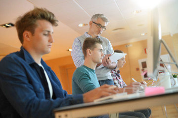 Group of students in computing class with teacher