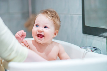 Funny baby bathing in the tub.