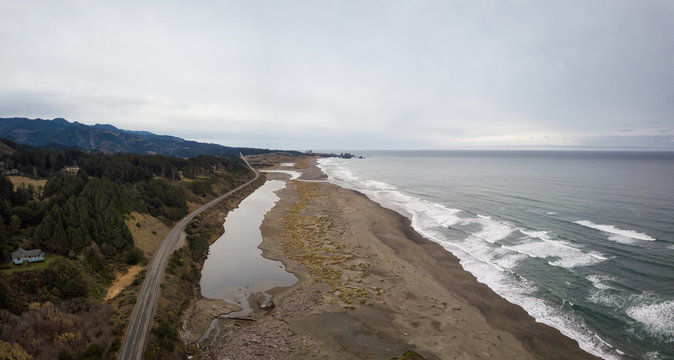 Aerial panoramic view of the Highway at Pacific Ocean Shore during a cloudy winter morning. Taken in Oregon Coast, North America.