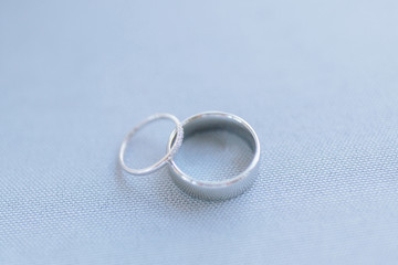 Couple of wedding rings close-up, luxury minimalistic wedding rings on grey background flat lay view with space for text.