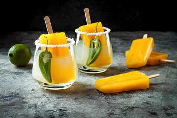 Spicy mango popsicle margarita cocktail with jalapeno and lime. Mexican alcoholic drink for Cinco de mayo party