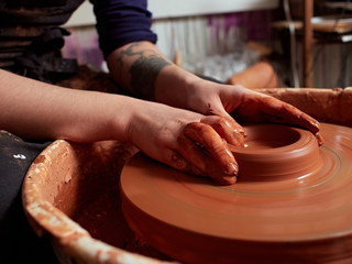 production process of pottery. Forming a clay teapot on a potter's wheel.