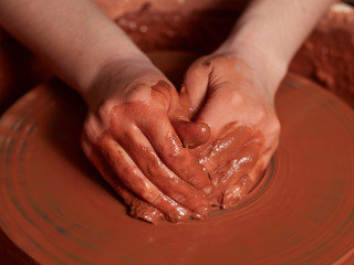 Forming a clay mug on a potter's wheel.