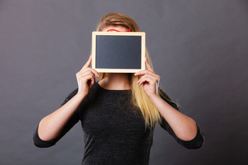 Woman holding blank black board on face