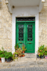 Closed double green doors with glass and metal grill.