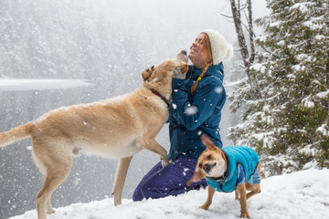 Girl playing with her dog in the snow. Taken near Squamish and Whistler, North of Vancouver, BC Canada. Concept: love, friendship, care