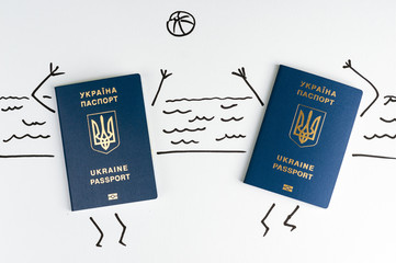 Two blue Ukrainian passports play ball on the beach. Isolate.