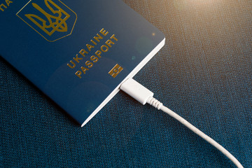 Summer light Ukrainian passport on a blue background with PowerBank, charging.