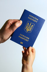 Blue Ukrainian passport in the hands of the child and the woman. Isolate