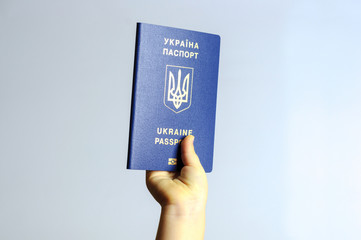 Blue Ukrainian passport in the hands of the child. Isolate