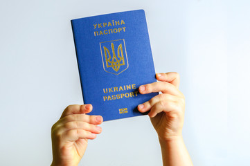 Blue Ukrainian passport in the hands of the child. Isolate