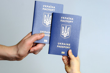 Blue Ukrainian passport in the hands of the child and the woman. Isolate