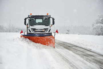 Snow plow clearing a snowy road