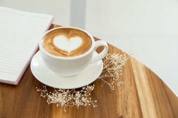 single coffee cup on wood table,heart shape latte art concept,love signature with coffee.