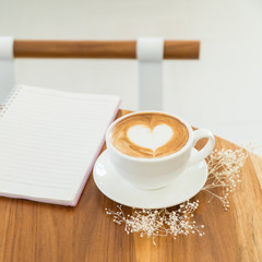 single coffee cup on wood table,heart shape latte art concept,love signature with coffee.