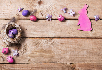 Easter eggs in nest on wooden background