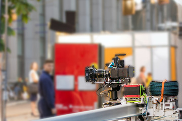 Big professional camera on rails. Outdoors movie set. Cinema production scene at city street.  Candid real filmmaking concept