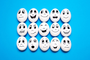 Eggs with drawn cartoon faces with various emotions in rows