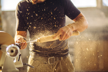 wood lathe, lathe operator working a wood pestle