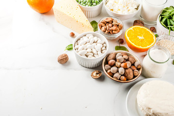 Healthy food concept. Set of food rich in calcium - dairy and vegan Ca products, white marble background copy space