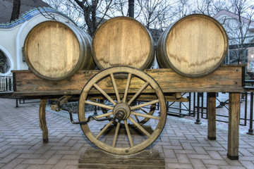 Fototapeta na wymiar Wine barrels on a cart in a paved courtyard