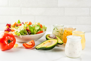 Set of classic salad dressings - honey mustard, ranch, vinaigrette, lemon & olive oil,  on white marble table, copy space
