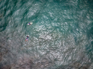 The surfer rides and swims on the board dissecting the waves of the ocean. Deep and boundless ocean. Aerial view with copy space.