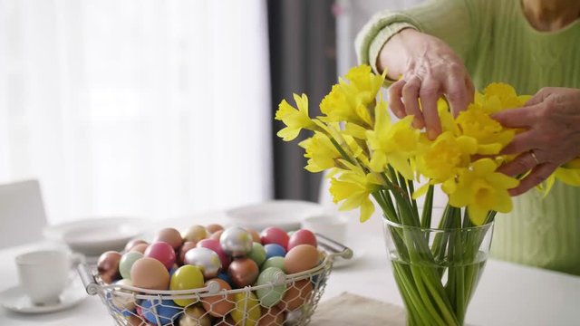 Unrecognizable senior woman arranging flower
