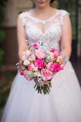 Bride holds in her hands wedding bouquet with pink roses. Wedding bouquet 