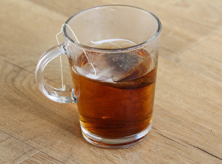 Glass of Moroccan mint tea with tea bag on wooden background