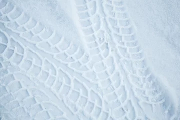 Foto auf Acrylglas Tire tracks pattern on winter road with snow © evannovostro
