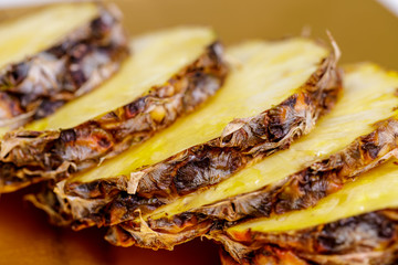 Pineapple fruit slice on wood plate. close up.