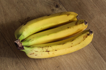 Fresh yellow common Bananas on wooden background