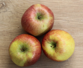 Red and yellow fresh braeburn apples on wooden background