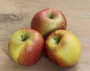 Red and yellow fresh braeburn apples on wooden background