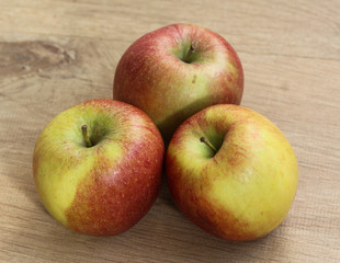 Red and yellow fresh braeburn apples on wooden background