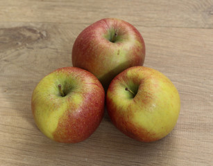 Red and yellow fresh braeburn apples on wooden background