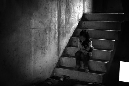 Depressed young girl sitting alone in an abandoned building