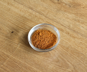 Glass bowl with hot cajun seasoning on wooden background