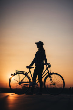 Woman riding a bike in the city during sunset