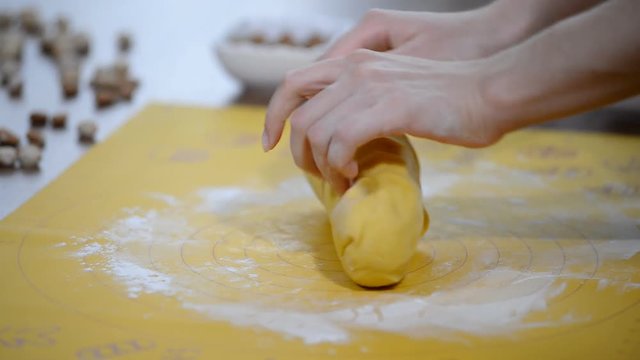 female hands in flour closeup kneading dough on table