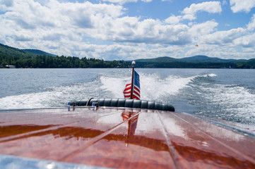 Wooden boat and flag on a lake in summer